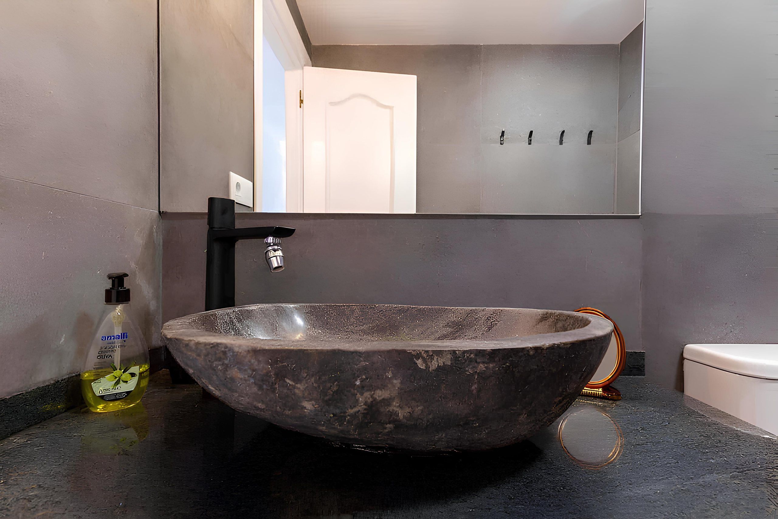 Stone basin with black tap in the bathroom