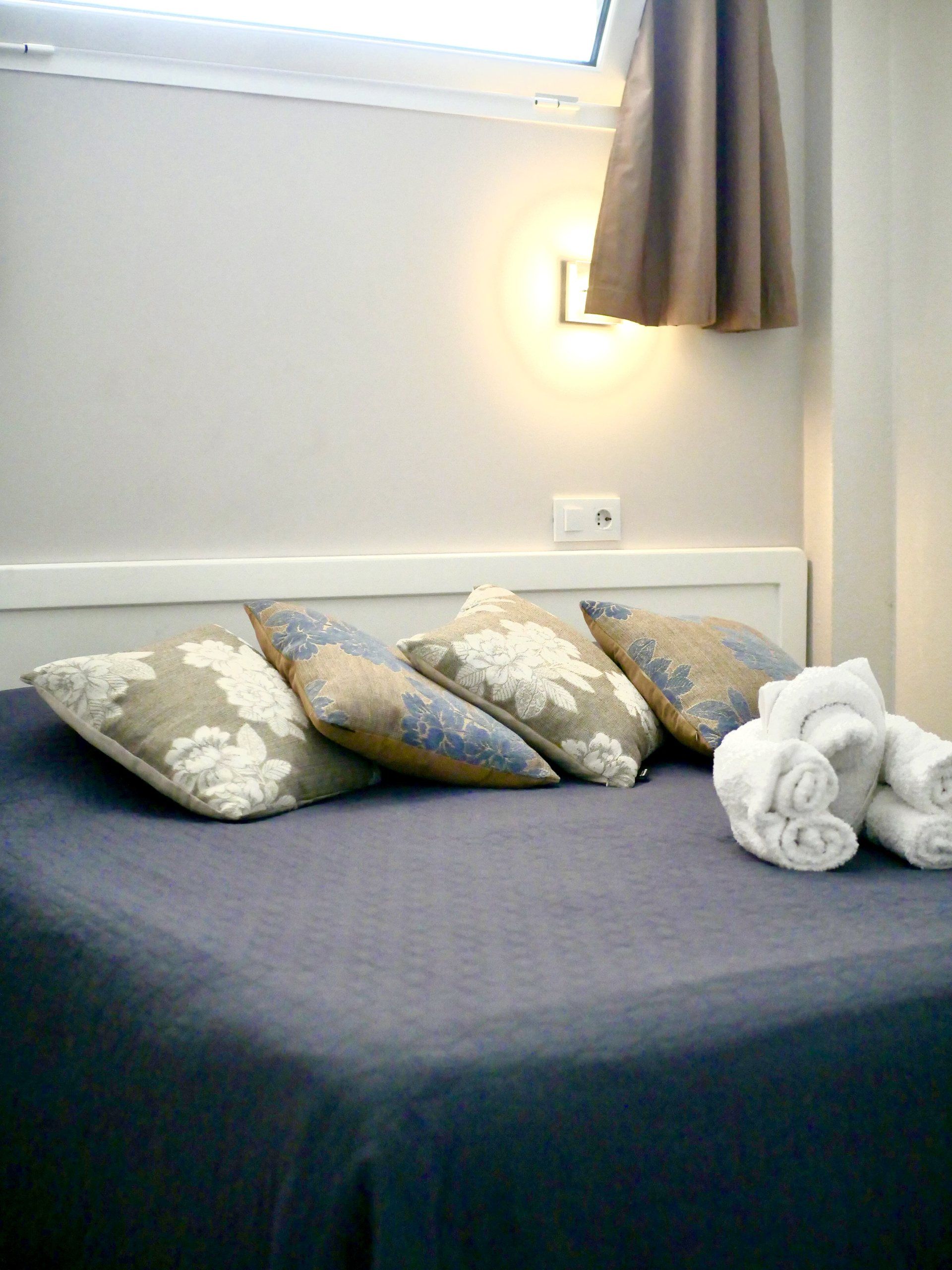 Bed with cushions and rolled towels