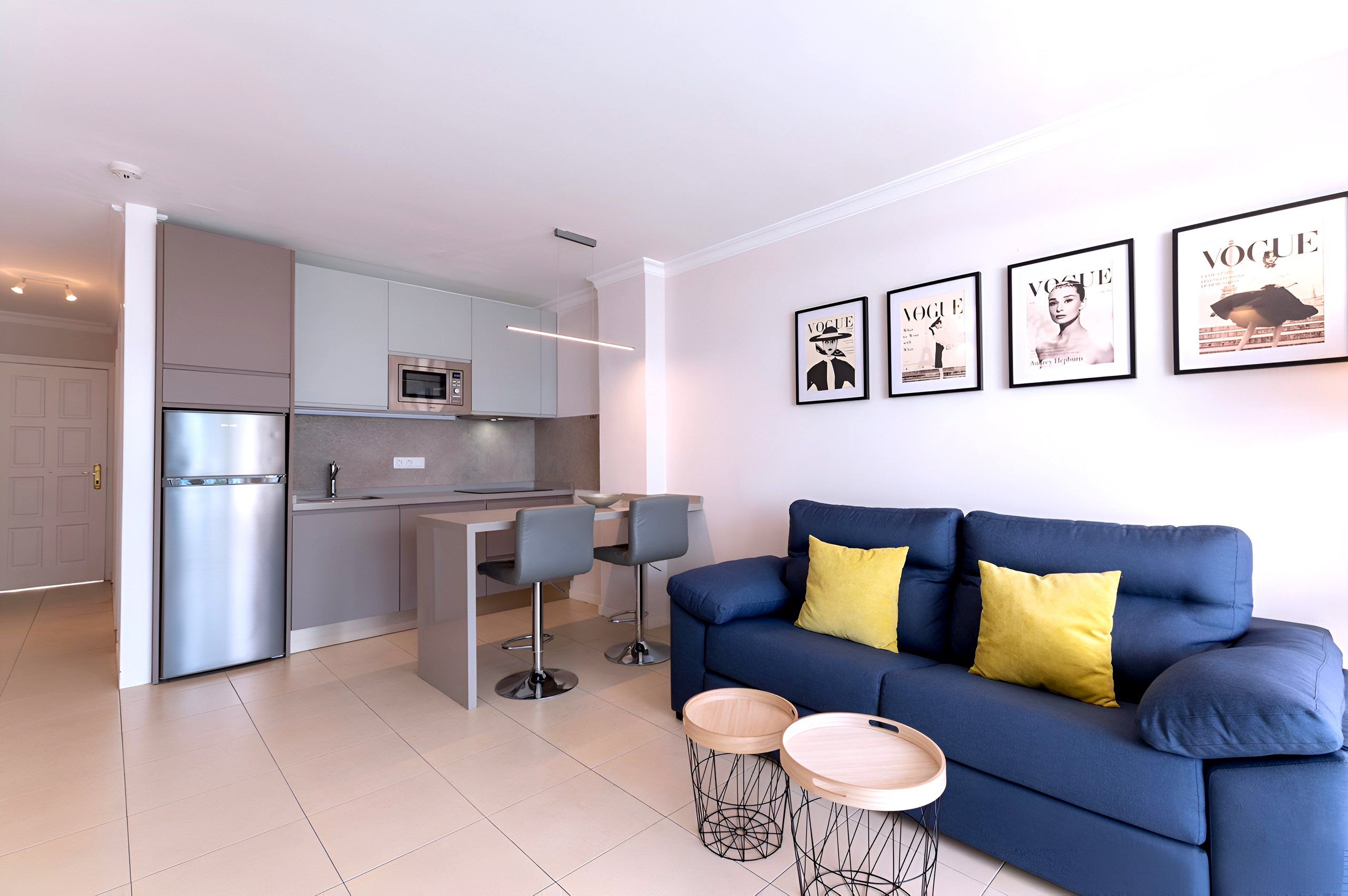Open-plan living area with blue sofa and kitchen