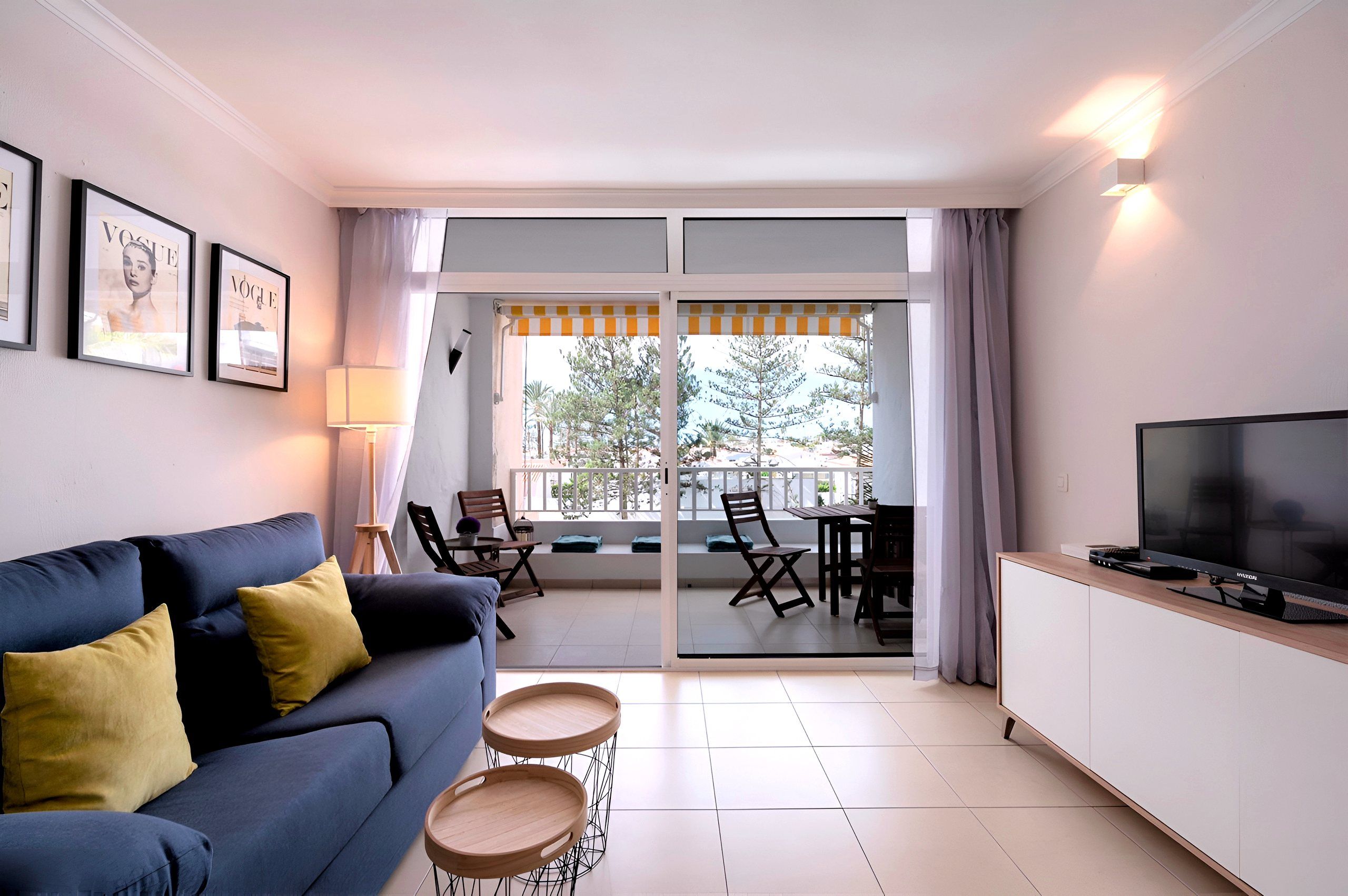 Living room with blue sofa and sliding doors to the loggia