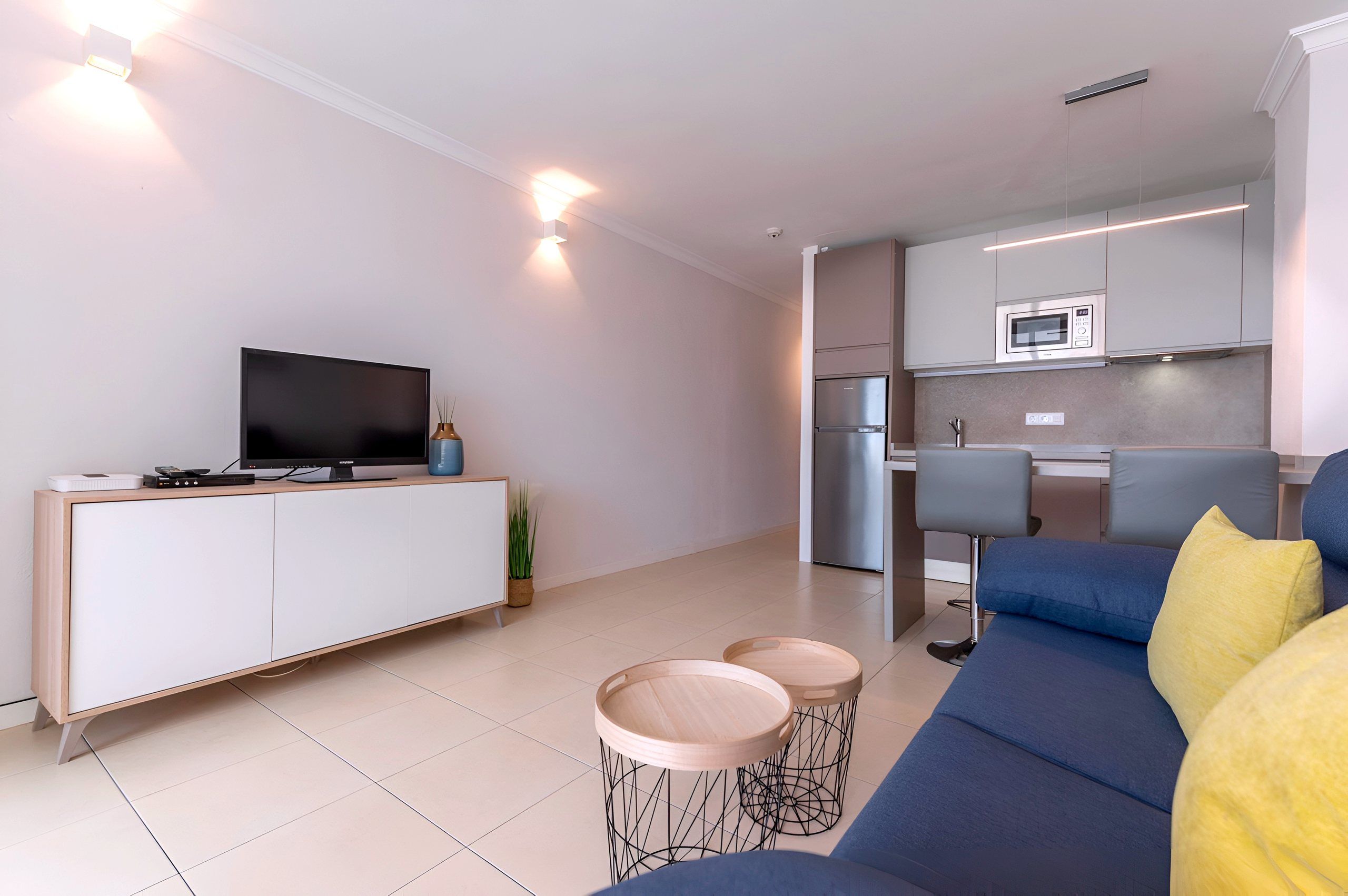 Living area with TV unit and kitchen behind